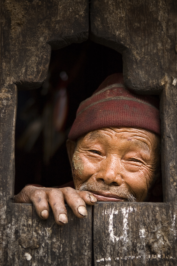 Profugo tamang affacciato alla finestra di casa sua nel villaggio di Gatlang. 